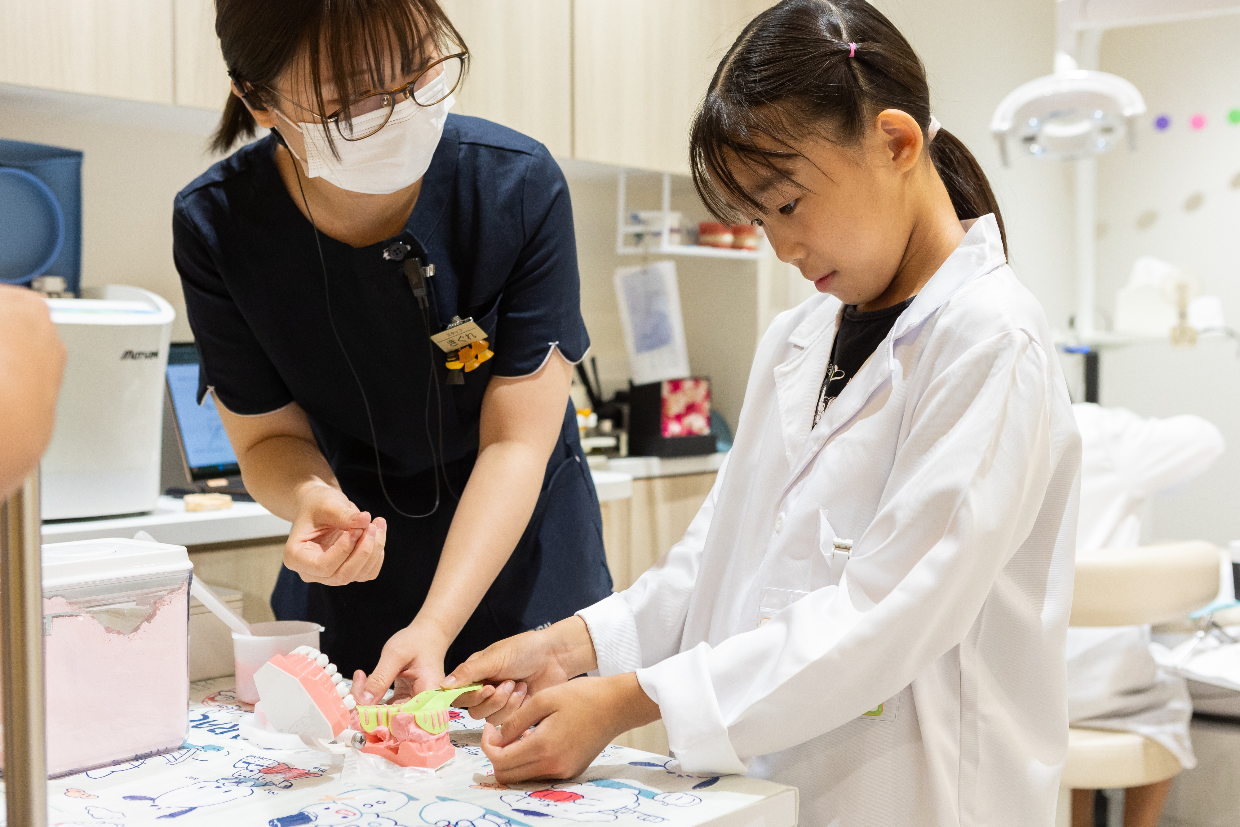 歯の模型を使って下の歯の型取りを体験する子ども