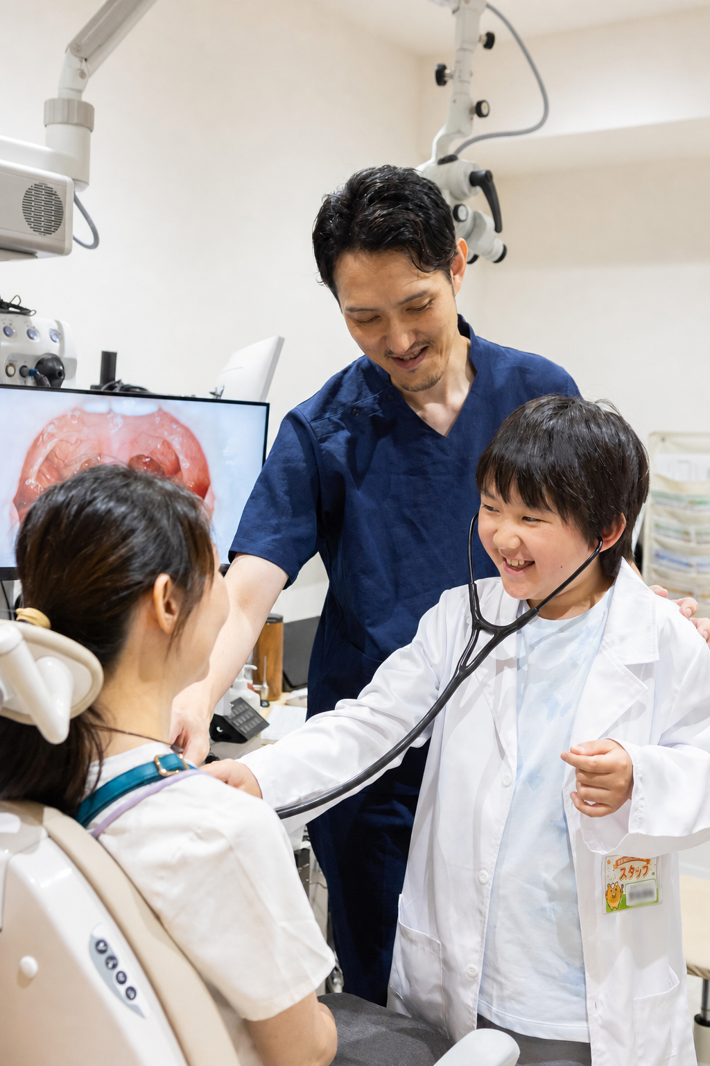 聴診器で保護者の呼吸音を聞く子ども