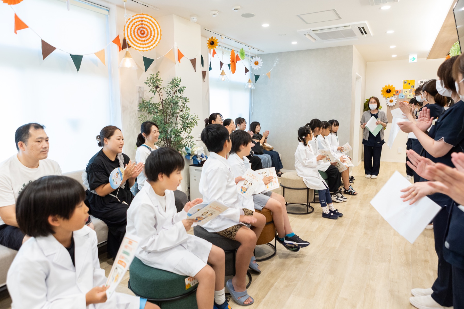 開会式で拍手する白衣姿の子どもたち