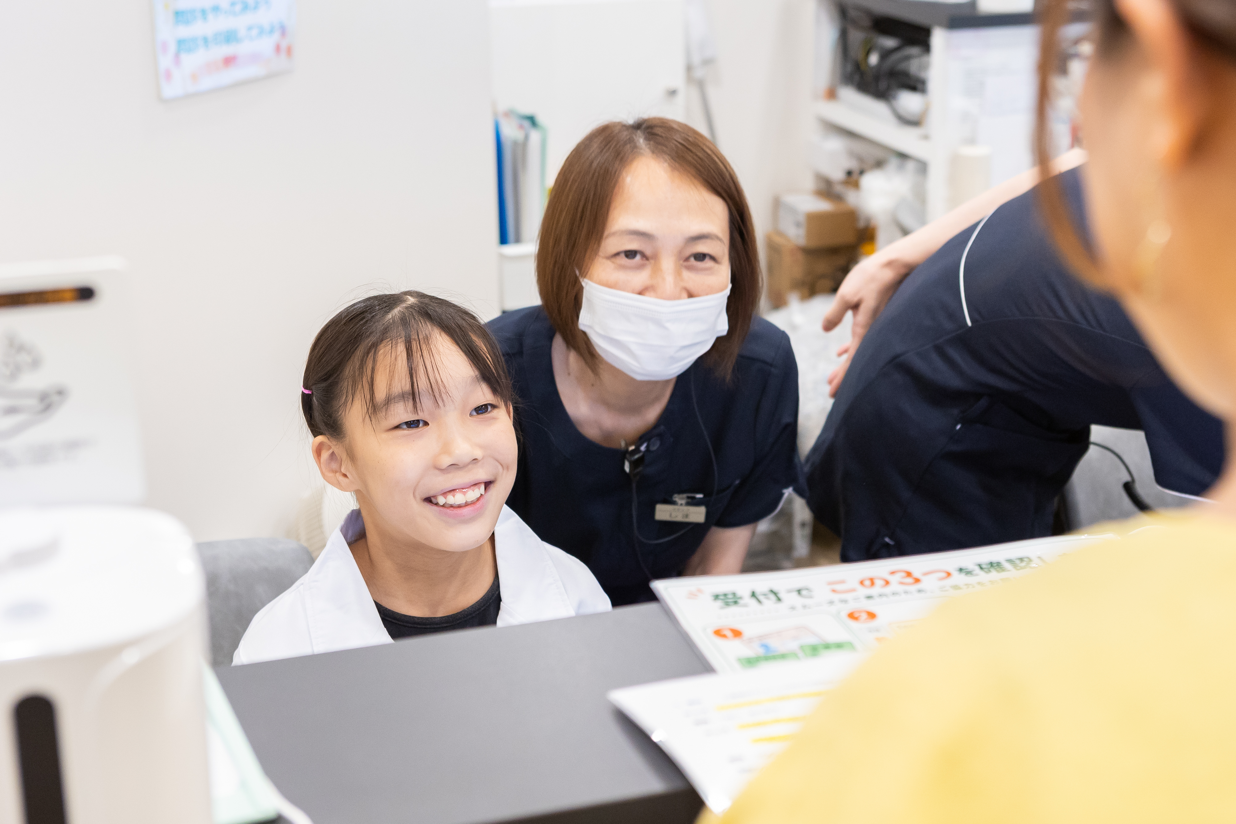 受付カウンターで笑顔で患者さんを迎える子ども