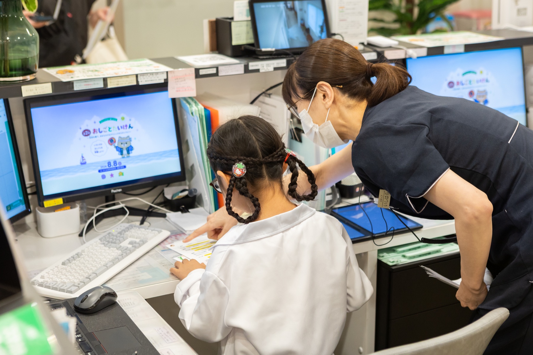 受付カウンターのパソコンを操作する子ども