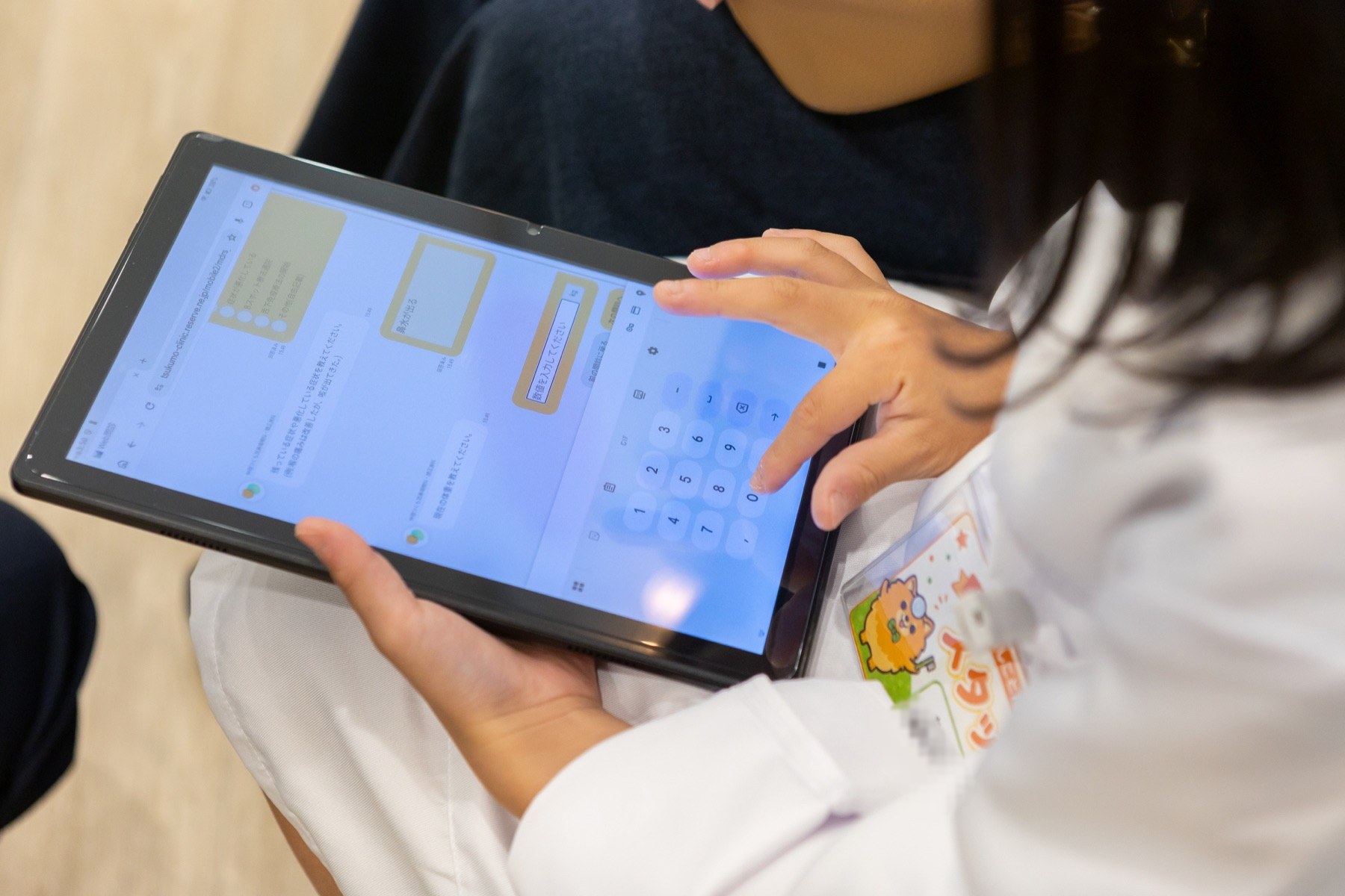 タブレットで問診を入力する子どもの手元